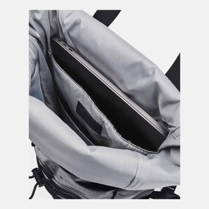 Black backpack by Under Armour, interior view with a laptop in a sleeve and multiple pockets.