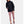 Black Cloudstrike Shell Jacket by Under Armour, hooded with a drawstring waist and reflective strips, worn over pink capri leggings.