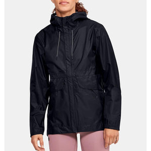 Black women's Cloudstrike Shell Jacket by Under Armour, featuring a hood with white drawstrings and two front flap pockets, worn over pink leggings.