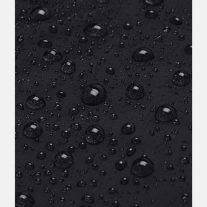 Women's black stormproof jacket by Under Armour, with a close-up of water beading on the fabric surface.