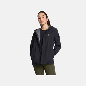 Black women's Stormproof Cloudstrike Stretch Jacket by Under Armour, with white logo, worn open over a black shirt and olive green leggings.
