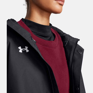 Black Women's Stormproof Lined Rain Jacket by Under Armour, with white chest logo, worn open over a red sweater and black turtleneck.