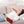 Black heating therapy pad by UTK Technology with red glowing elements, wrapped on a woman's forearm while she relaxes on a couch.