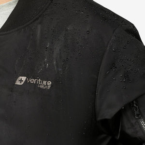 Cropped black water-resistant bomber jacket by Venture Heat showing water droplets, an embroidered logo, and sleeve zipper.