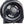 Black full-size whole room air circulator fan by Vornado, showing the front grille and central control dial from a side view.
