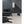 Black whole room heater by Vornado, a compact fan-style unit with a red logo on a light tiled floor.