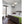 White evaporative humidifier by Vornado with a round top grille, sitting on a dark wood floor.