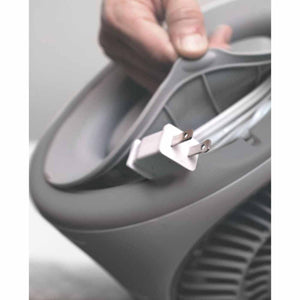Ice white small nursery heater by Vornado with a person's hand opening its back cord storage compartment revealing a white plug.