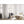 A stainless steel whole room heater by Vornado, compact and square with a black grille, on a light wooden floor in a modern office.