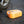 Orange tire inflator by Wagan with a black hose and light, shown on asphalt connected to a car tire.