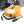 Orange digital tire inflator by Wagan with bright LED light, power cable, and inflation accessories, foregrounding an SUV in a snowy forest.