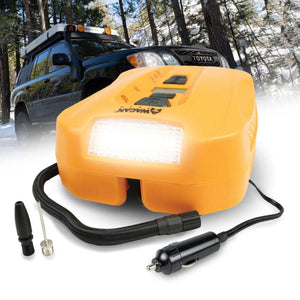 Orange digital tire inflator by Wagan with bright LED light, power cable, and inflation accessories, foregrounding an SUV in a snowy forest.