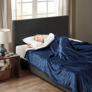 Blue King-size plush heated blanket by Woolrich, featuring a quilted pattern, covering a sleeping woman.