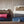 Multiple ribbed heated plush to berber blankets by Woolrich in various colors, with a controller visible, stacked on a wooden surface.