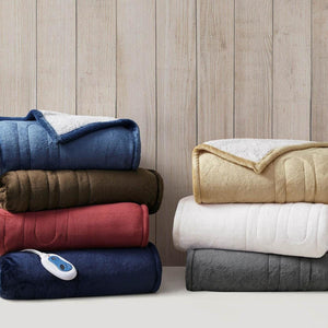 Heated Plush to Berber Throw in multiple colors by Woolrich, stacked, with a heating control visible.