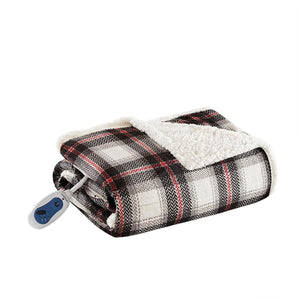Heated throw with black, white, and red plaid print by Woolrich, folded showing fluffy white berber lining and an attached remote controller.