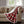 Red plaid heated throw by Woolrich with soft white berber lining and remote controller, draped over a sofa.